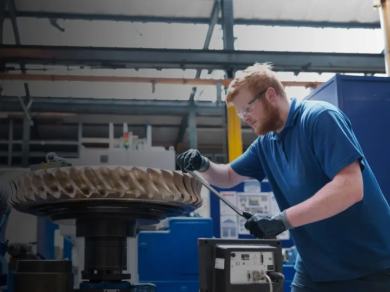 Machinist finishing a large gear on the shop floor